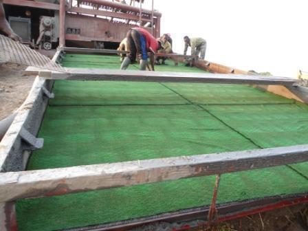 Workers operating a sluice washing plant to concentrate gold-bearing gravel at a MOUHDJAF site